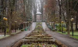 Deptak w Polanicy-Zdroju jesienią, z altaną i klombami.