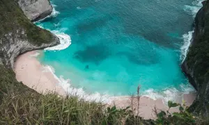 Widok z góry na plażę Kelingking na Nusa Penida z turkusową wodą i klifami.