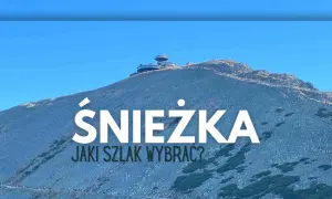 Szczyt Śnieżki z widocznym budynkiem obserwatorium. Na zboczu góry widać ludzi idących szlakiem.