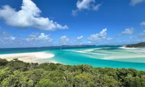 Widok na Whitehaven Beach z góry: turkusowa woda, biały piasek i zieleń.