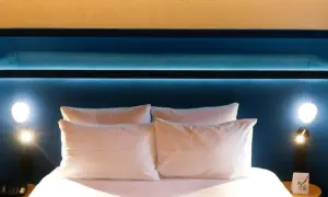 Komfortowe łóżko z białymi poduszkami w pokoju hotelowym Mercure Warszawa Centrum.