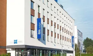 Nowoczesny budynek hotelu ibis budget z niebieskimi banerami.