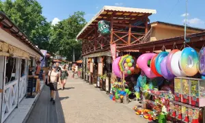 Skorzęcin atrakcje: kolorowe koła do pływania, zabawki i budki z grami na deptaku. Słoneczny dzień zachęca do spacerów.
