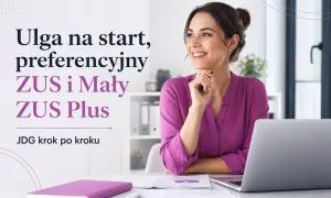 Uśmiechnięta kobieta przy biurku, myśląca o ulga na start, preferencyjny ZUS i Mały ZUS Plus. JDG krok po kroku.