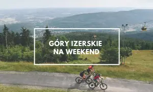 Góry Izerskie Polska: rowerzyści pędzą po górskiej drodze, a w tle kolejka gondolowa i rozległy krajobraz.