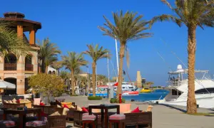 Relaks przy kawie w Port Ghalib, z palmami i jachtami w tle.