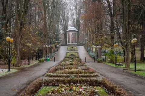 Deptak w Polanicy-Zdroju jesienią, z altaną i klombami.