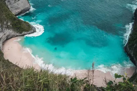 Widok z góry na plażę Kelingking na Nusa Penida z turkusową wodą i klifami.