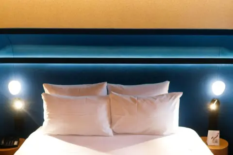Komfortowe łóżko z białymi poduszkami w pokoju hotelowym Mercure Warszawa Centrum.