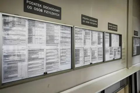 Tablice informacyjne z drukami PIT i informacjami o podatku dochodowym od osób fizycznych. Widać napisy "Podatek dochodowy od osób fizycznych", a także formularze, które mogą dotyczyć 3 progu podatkowego.