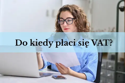 Kobieta w okularach analizuje dokumenty przy laptopie. Pytanie "Do kiedy płaci się VAT?" pojawia się na jasnoniebieskim tle.