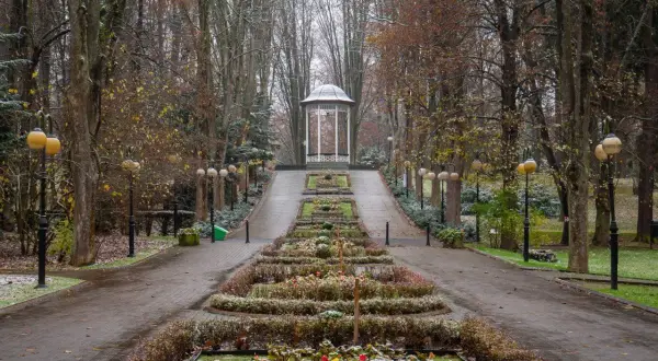 Deptak w Polanicy-Zdroju jesienią, z altaną i klombami.