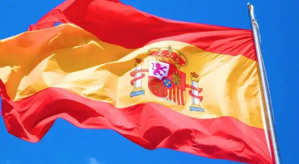 Flaga Hiszpanii powiewa na wietrze. Zastanawiasz się, ile się leci do Barcelony?