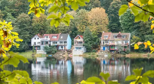 Idealna wycieczka na niedzielę na Dolny Śląsk: domki nad jeziorem w jesiennej scenerii, odbijające się w spokojnej wodzie.
