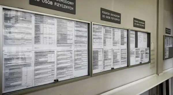 Tablice informacyjne z drukami PIT i informacjami o podatku dochodowym od osób fizycznych. Widać napisy "Podatek dochodowy od osób fizycznych", a także formularze, które mogą dotyczyć 3 progu podatkowego.