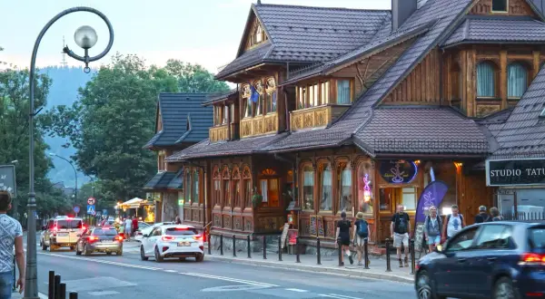 Spacer po Krupówkach, gdzie drewniana architektura przeplata się z ruchem ulicznym i turystami.