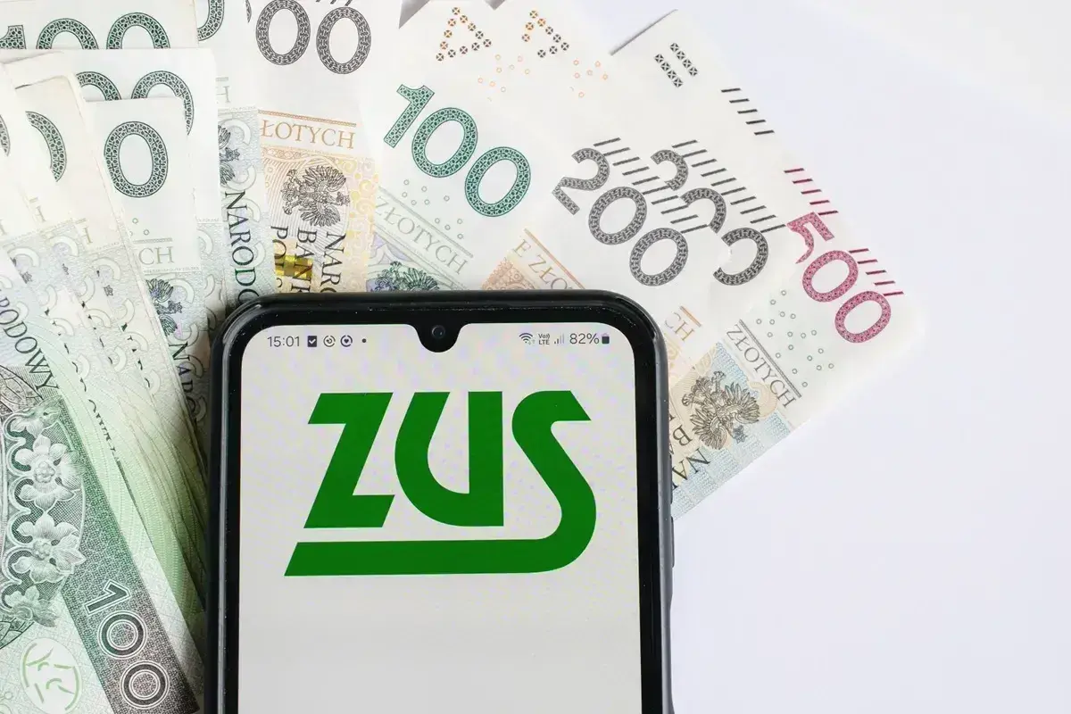 ZUS na ekranie telefonu, obok polskie banknoty. Czas na wniosek o zwrot nadpłaty ZUS.