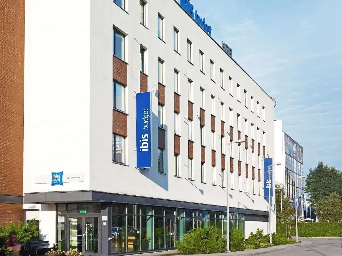 Nowoczesny budynek hotelu ibis budget z niebieskimi banerami.