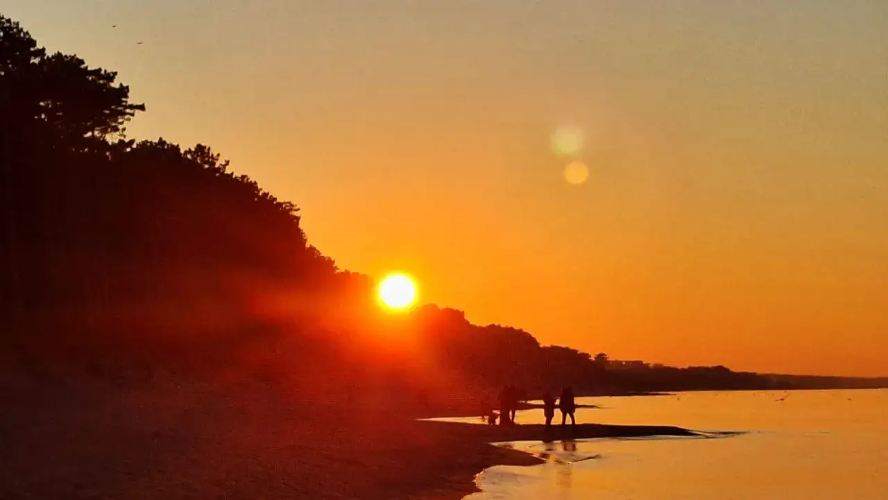 Zachód słońca nad morzem w Mielnie. Spacer po plaży to jedna z atrakcji dla dorosłych, idealna na romantyczny wieczór.