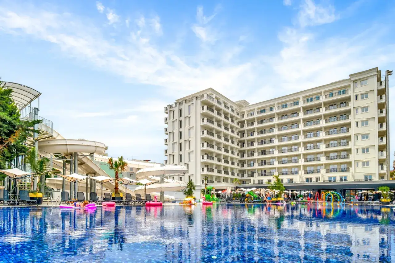 Albania - wczasy samolotem all inclusive. Basen, zjeżdżalnie wodne i hotel w słoneczny dzień. Idealne miejsce na relaks.