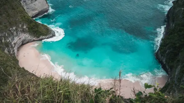 Widok z góry na plażę Kelingking na Nusa Penida z turkusową wodą i klifami.