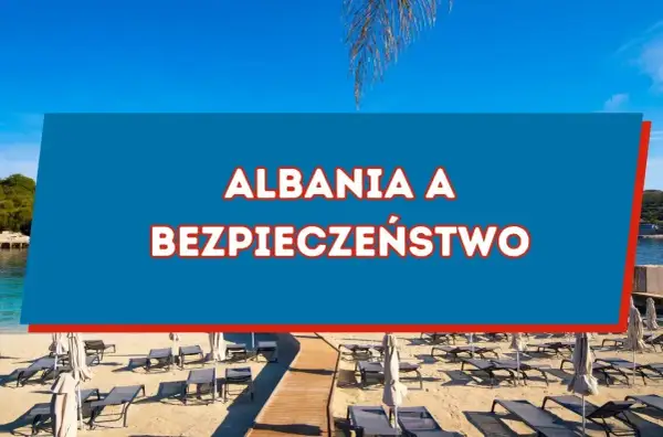 Piękna plaża w Albanii, gdzie słońce świeci, a leżaki czekają. Czy w Albanii jest bezpiecznie? Odpowiedź znajdziesz na niebieskim tle.