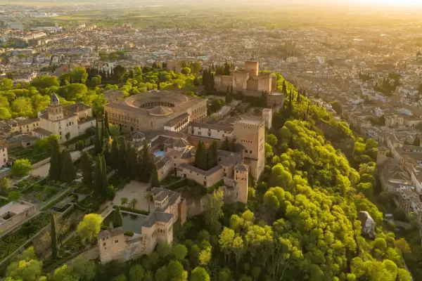 Widok z lotu ptaka na Alhambrę w Granadzie, otoczoną bujną zielenią. Marzysz o zwiedzaniu? Sprawdź alhambra bilety!