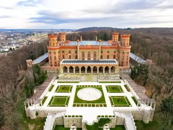 Imponujący Kamieniec Ząbkowicki zamek, otoczony lasem, z malowniczym ogrodem i dziedzińcem.