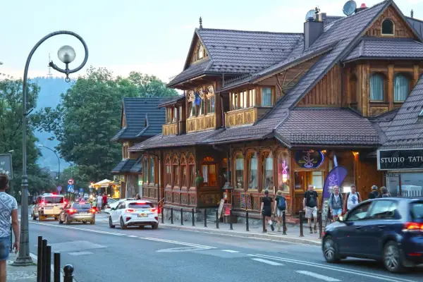 Spacer po Krupówkach, gdzie drewniana architektura przeplata się z ruchem ulicznym i turystami.