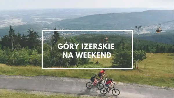 Góry Izerskie Polska: rowerzyści pędzą po górskiej drodze, a w tle kolejka gondolowa i rozległy krajobraz.