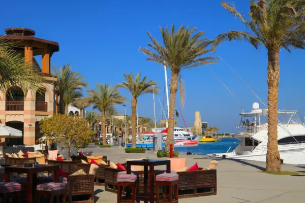Relaks przy kawie w Port Ghalib, z palmami i jachtami w tle.